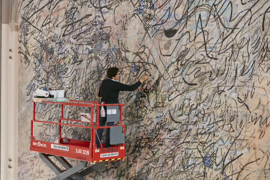 Painter Julie Mehretu stands on a large mechanical lift to work on a very largescale abstract painting.