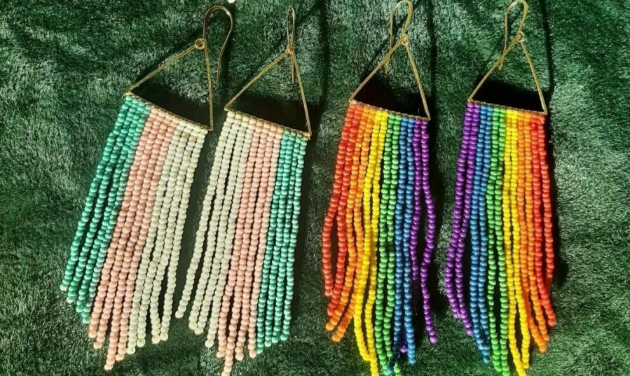 Two sets of fringe earrings one with blue, pink and white stripes and the other with rainbow colours.