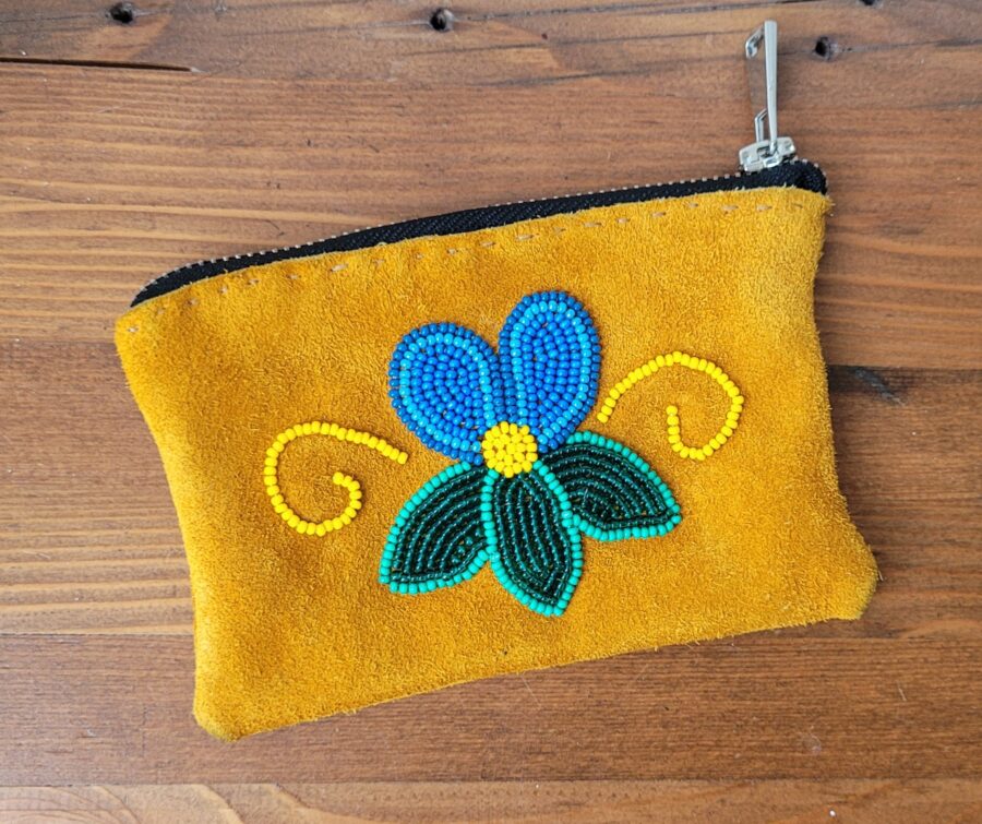 A small rectangular pouch with a zipper. Made out of hide with a blue flower beaded design.