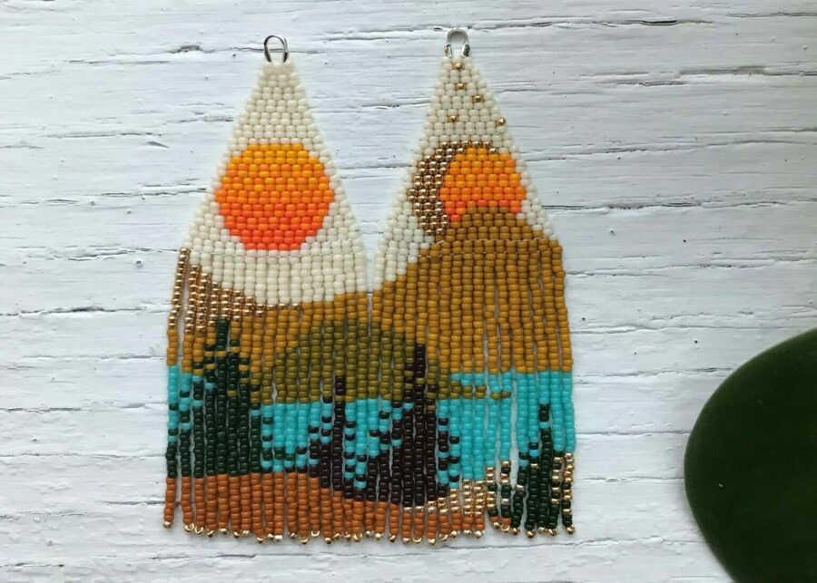 Beaded fringe earrings depicting a landscape with trees in the foreground and hills in the background by Adeline Cook.