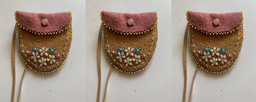 Three repeated images of a belly button bag by Candace Neumann. The bags are small, made with leather and have a folded over top and a simple beaded flower design.