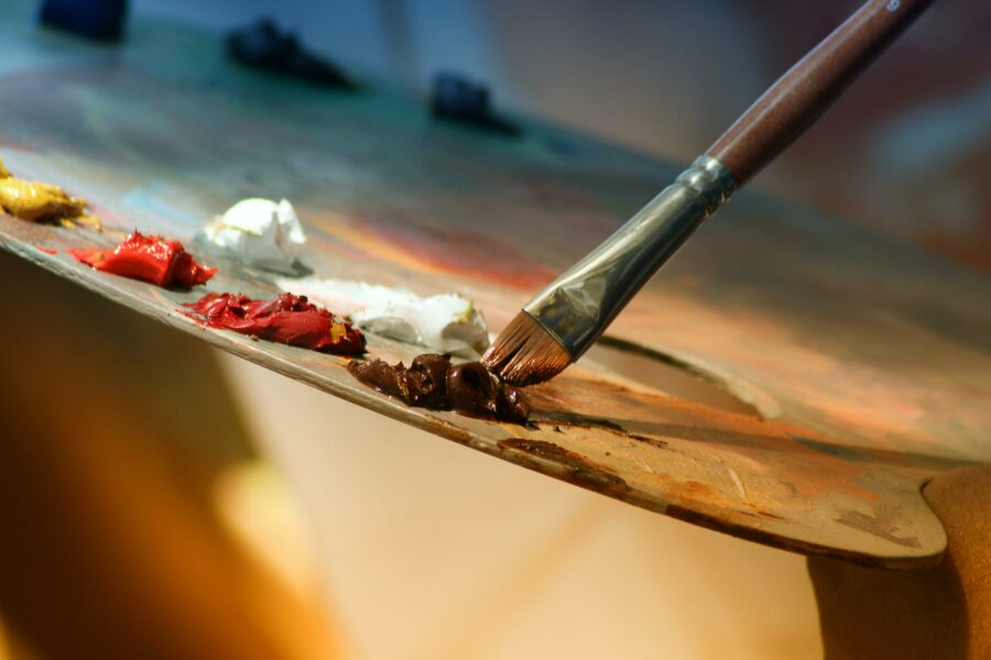A wooden painters' palette and paint brush