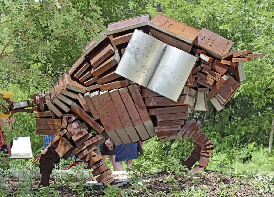 Outdoor sculpture of a bison made out of books.