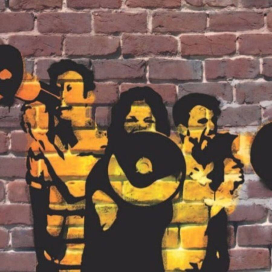 Black and yellow stenciled street art on a brick wall of three people yelling into megaphones.