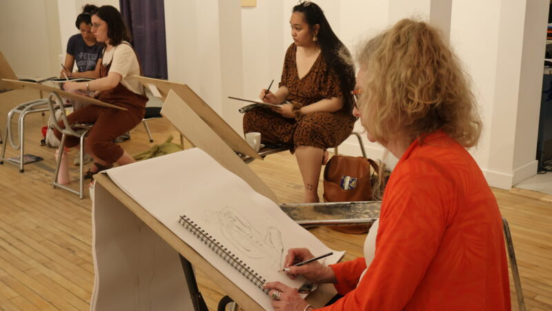 4 people sit on drawing horses in MAWA sketching.