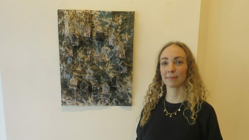 Ashley Huot stands next to her artwork.