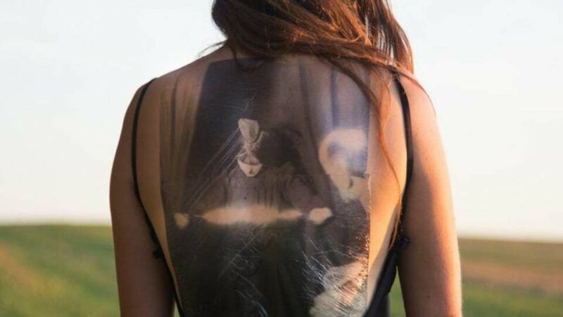 A woman's back with a image of a seance on it.