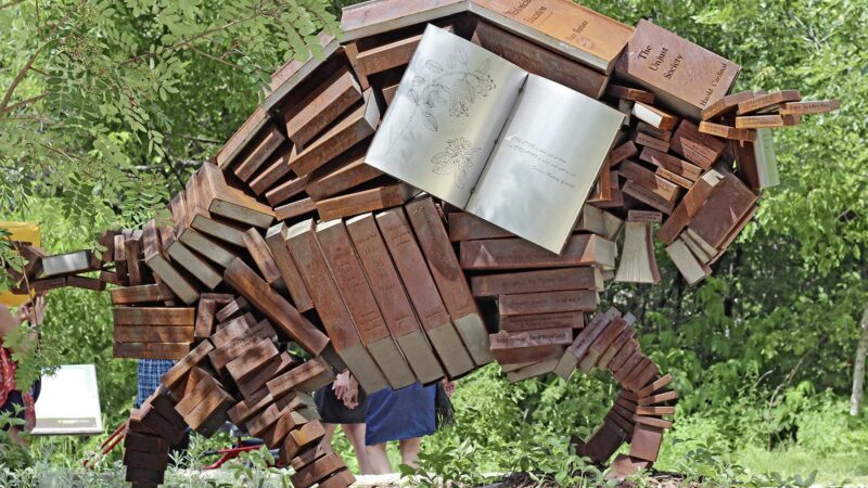 Outdoor sculpture of a bison made out of books.